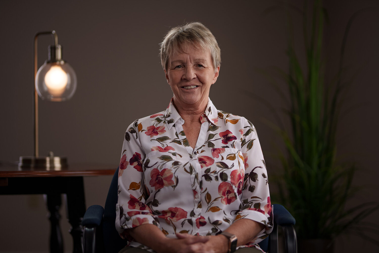 A woman sitting in a chair in front of a lamp. profile picture