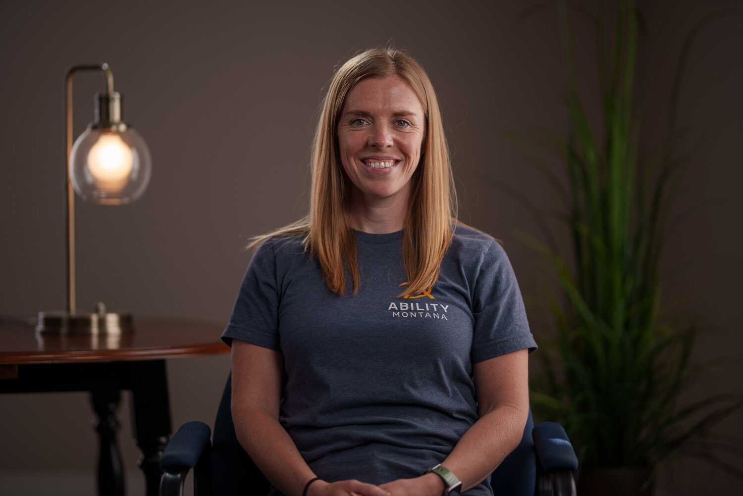 A woman sitting in a chair in front of a lamp. profile picture