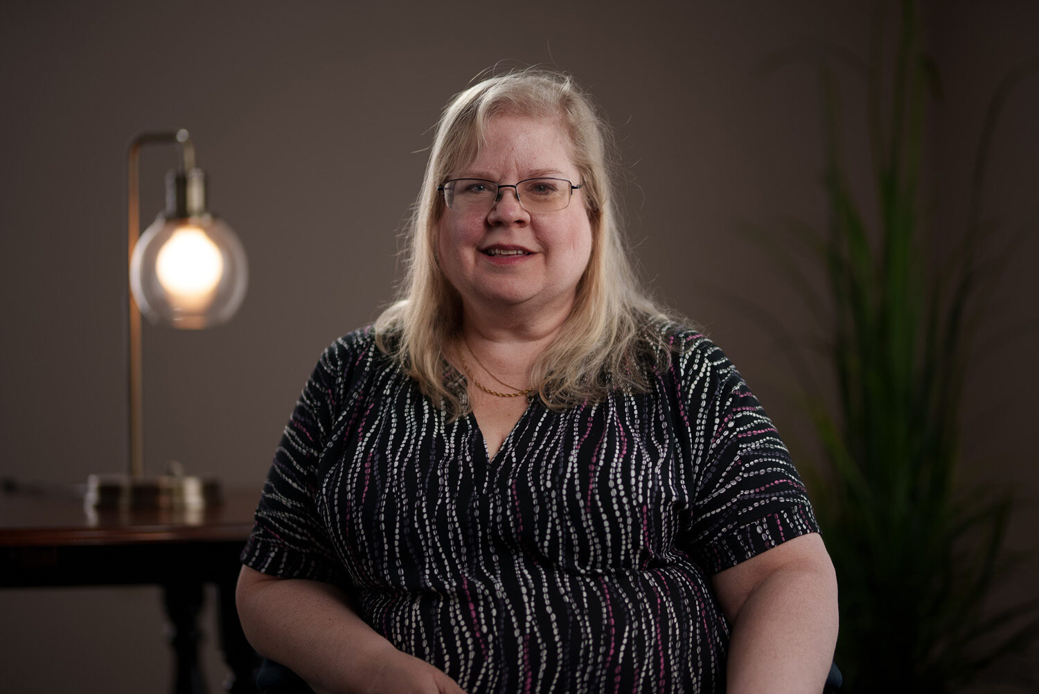 A woman sitting in front of a lamp. profile picture